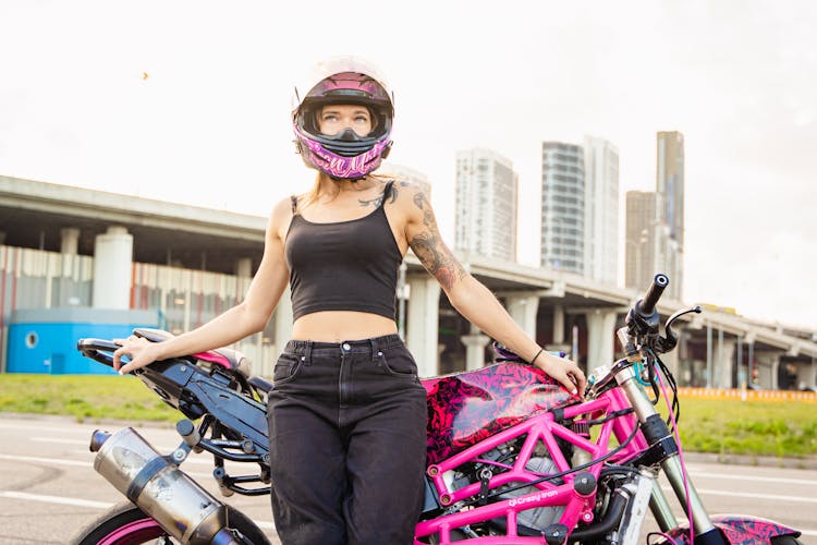 Woman Wearing A Helmet Leaning On Her Motorcycle