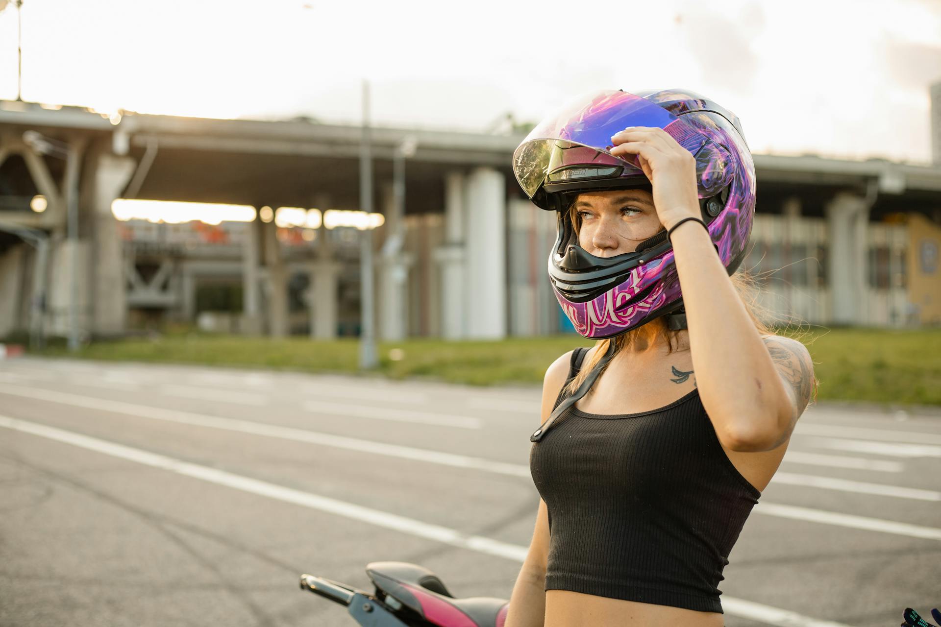 Young Woman in a Motorcycle Helmet on the Roadside