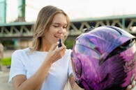 Woman in White Shirt Putting on Lipstick