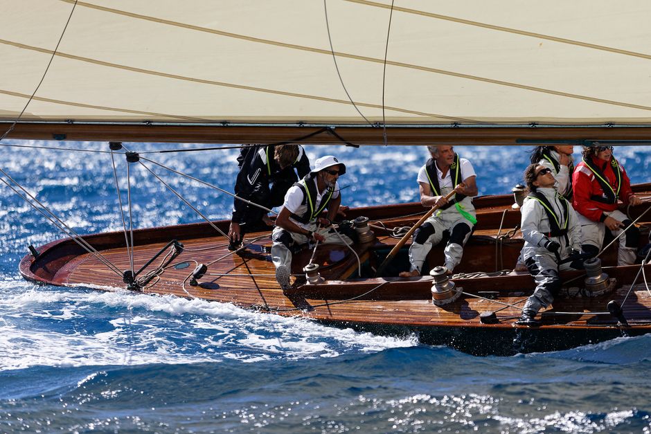 Best Capri Shared Tour: Caves, Dives, Limoncello and Caprese Cake Review 2026 - Sailing team maneuvering a classic yacht in vibrant blue waters during a race.
