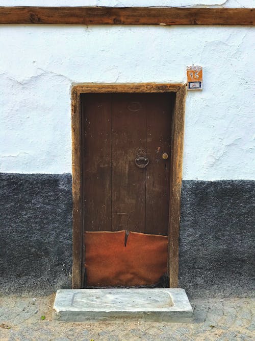 Rustic Brown Wooden Door on White Concrete Wall
