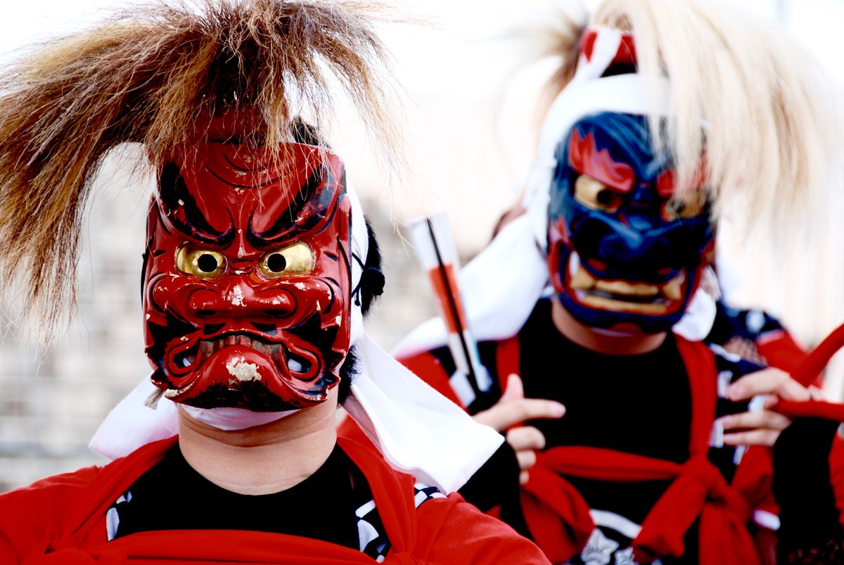 Performers wearing red and blue demon masks at a festival in Kitakami, Iwate