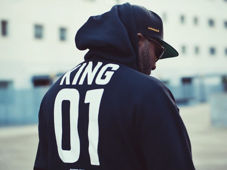 Man Wearing Black King 01-printed Hoodie And Flat Brim Cap