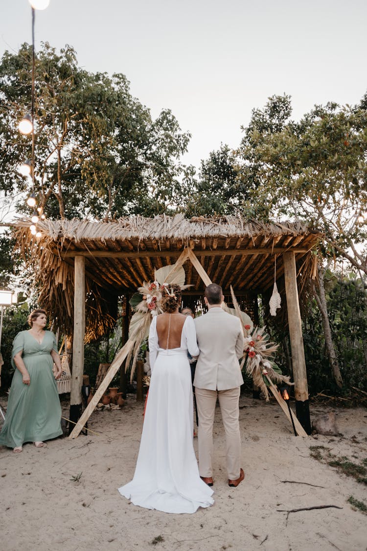 Outdoor Wedding Of Woman In White Dress Standing Beside Man In Gray Suit