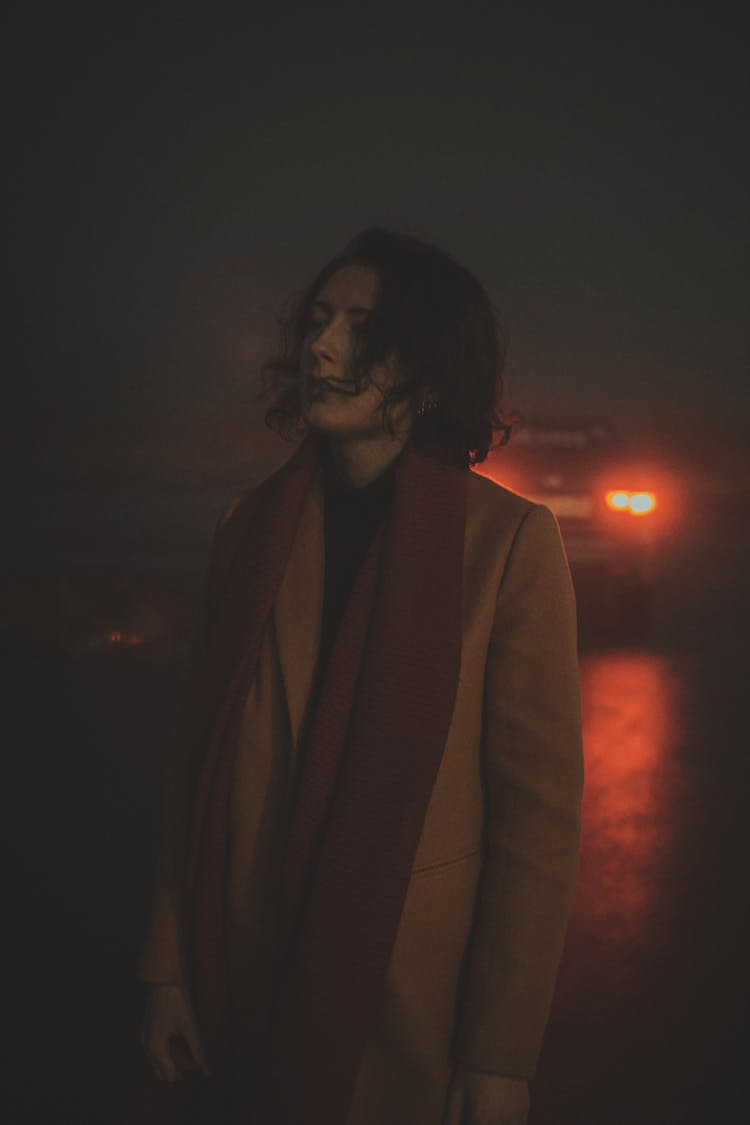 Adult Woman Standing At Night With Car In Behind