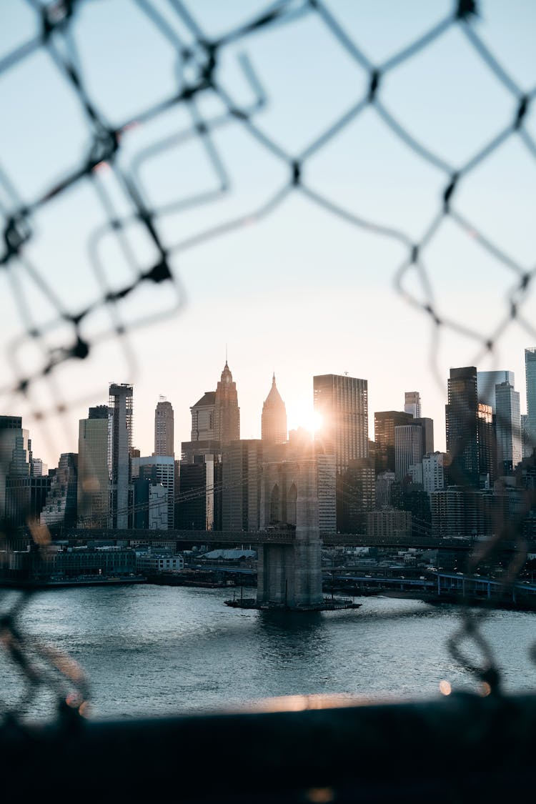 View Through Hole In Fence On Bridge On Skyscrapers In City