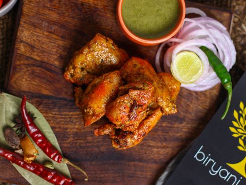 Free Delicious tandoori chicken with chutney, spices, and sliced onions, perfect for Indian cuisine lovers. Stock Photo