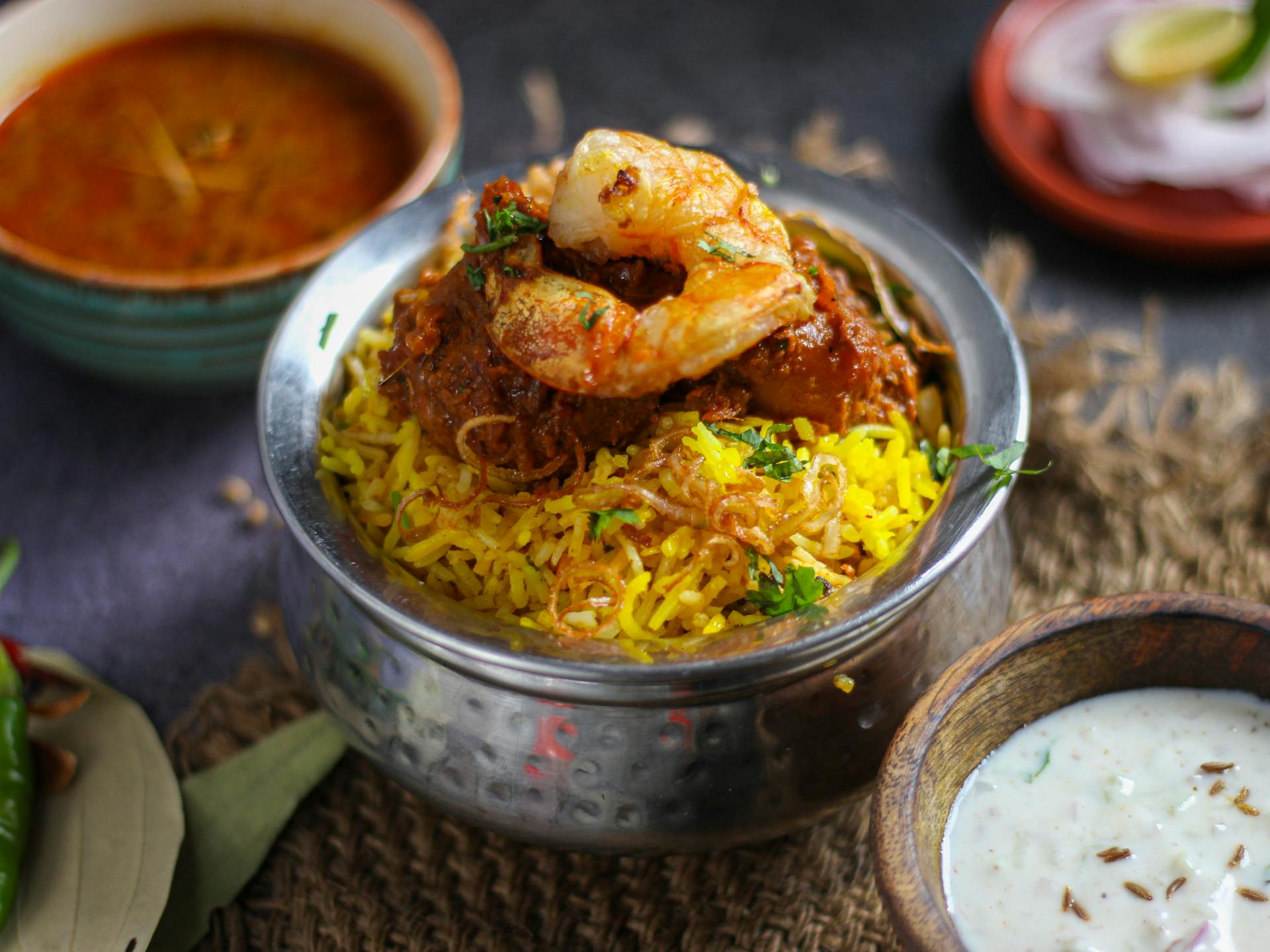 Delicious shrimp biryani with Indian spices, served with traditional condiments in New Delhi, India.
