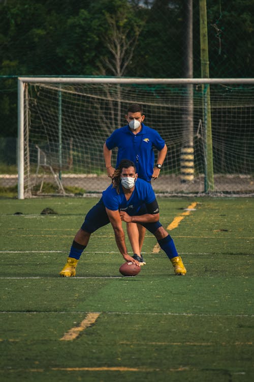 Men in Blue T-Shirts and Face Masks Playing American Football