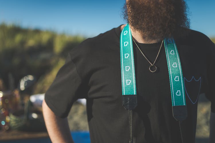 A Man In Black T-shirt With Green Lanyard