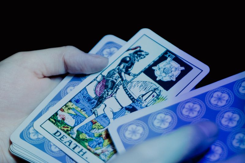 Close-up of hands holding tarot cards in a mysterious setting