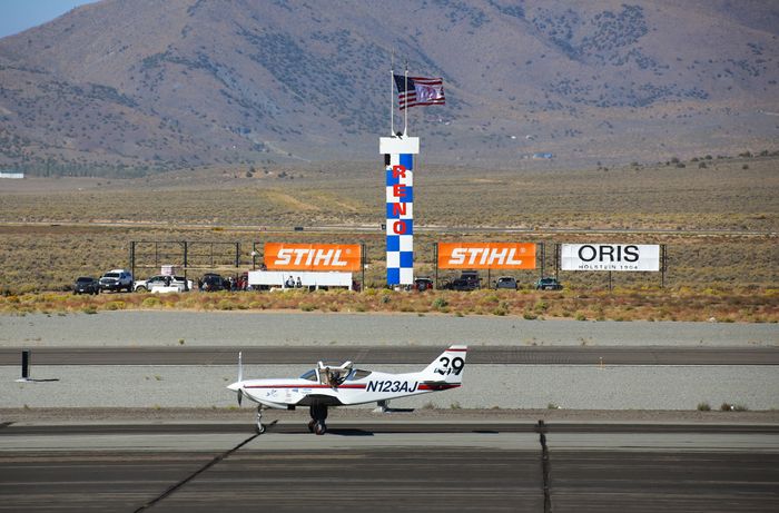 Single-engine aircraft on runway with air traffic control tower