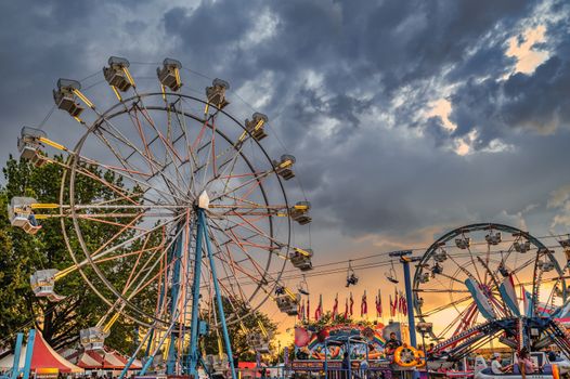People Riding on White and Blue Ferris Wheel Under Blue and White Cloudy Sky
