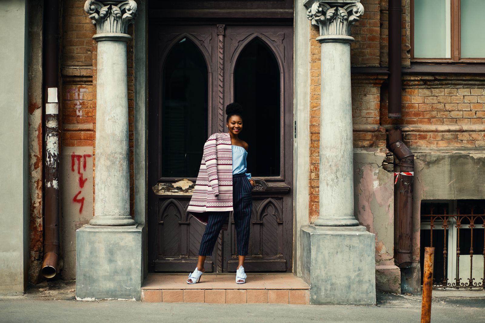Woman in a striped jacket in an old doorway