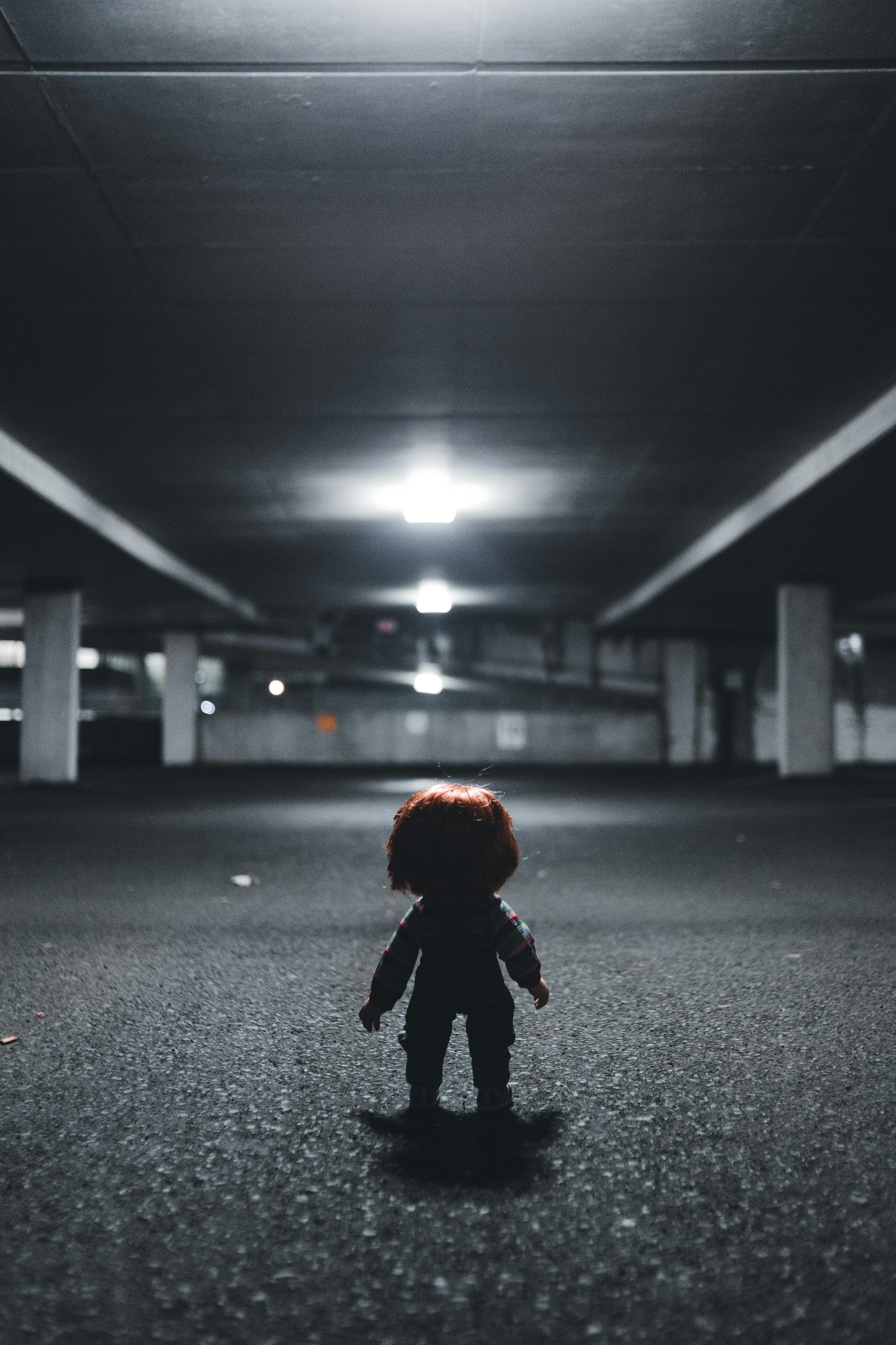 small doll in empty indoor car park