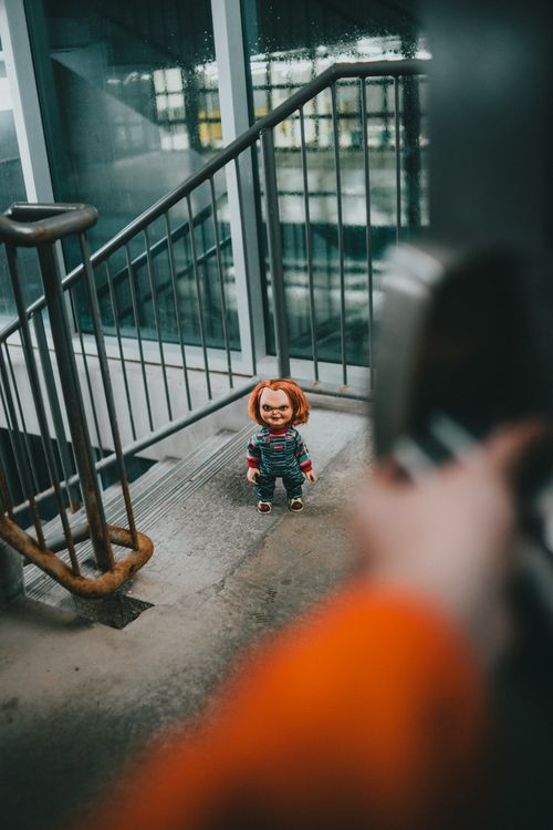 Free A doll with an eerie expression stands on an industrial staircase. Stock Photo
