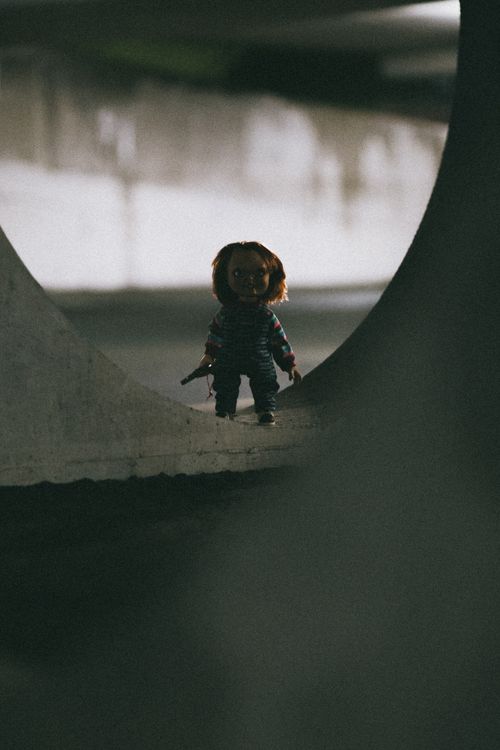 Free Eerie doll figure standing alone in a dimly lit tunnel, creating a horror ambiance. Stock Photo