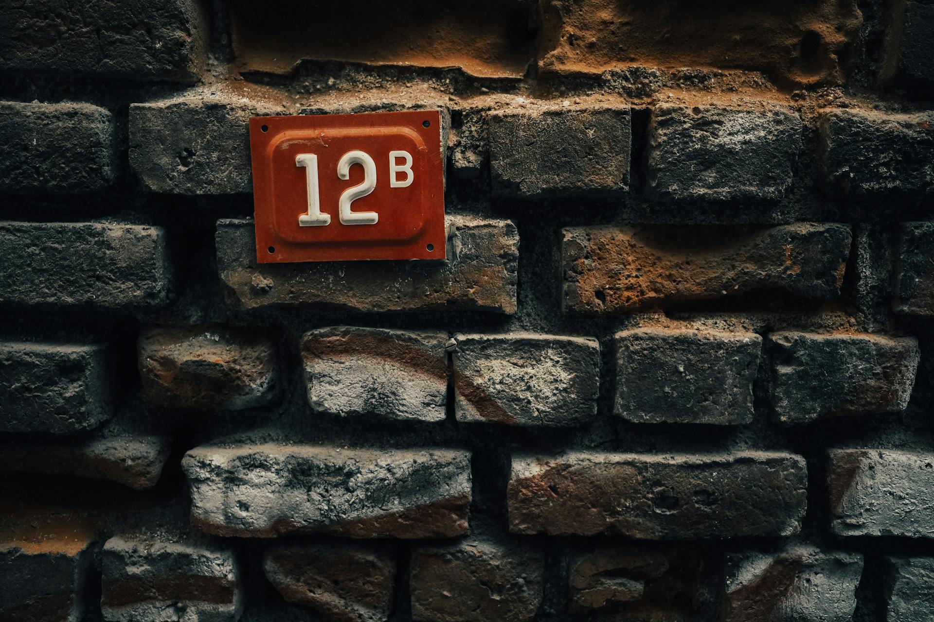 Brown House Number Metal Plate on Gray Stone Wall
