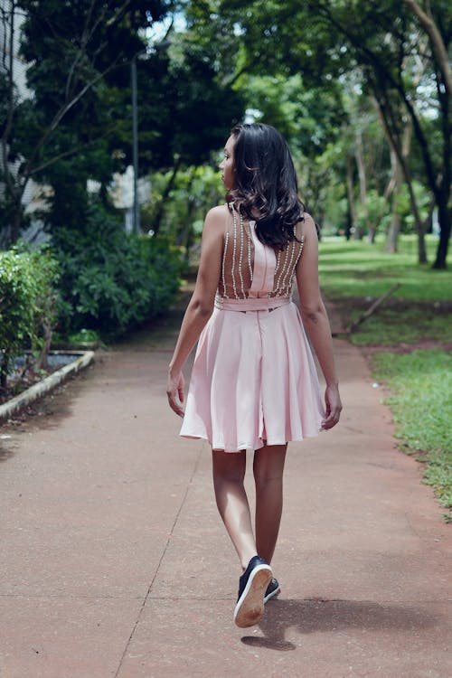 Woman Wearing Pink Mini Dress Walking on Walkway