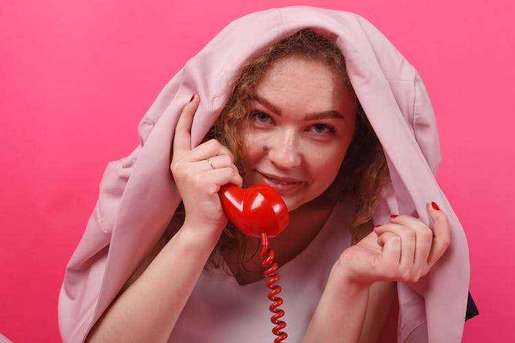 A Woman Holding A Telephone Under A Blazer