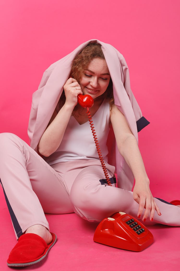 A Woman Holding A Telephone Under A Blazer