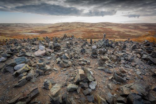 Free Expansive desert scene with scattered rocks under a dramatic, cloudy sky. Stock Photo