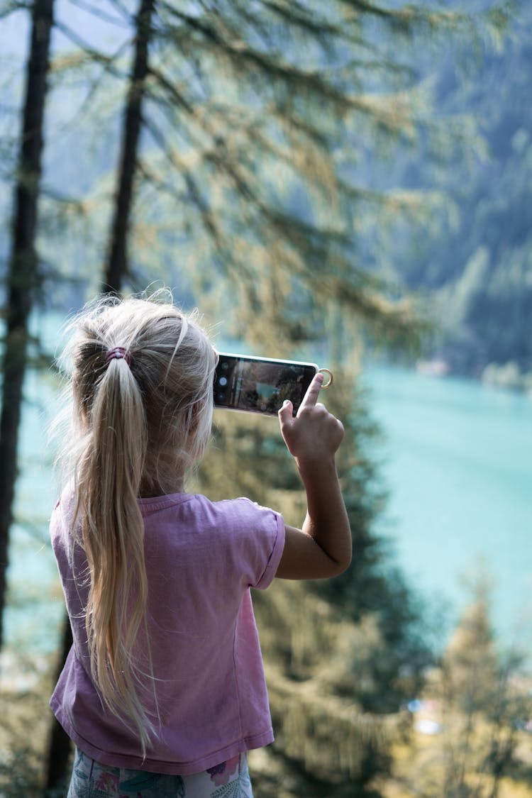 Child Taking Photo On Cellphone In Forest