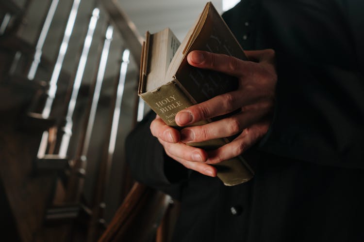 A Person Holding A Bible 