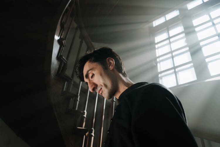 Priest Standing Beside A Staircase