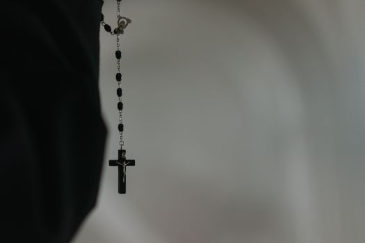 Silver Cross Pendant Necklace on White Textile