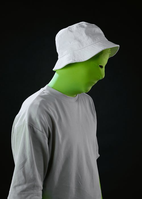 Man in White Crew Neck Shirt Wearing Green Cap