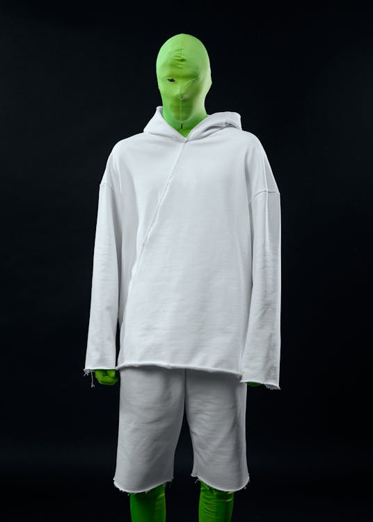 A Person in a Green Chroma Suit Wearing a Hoodie Sweater and Shorts