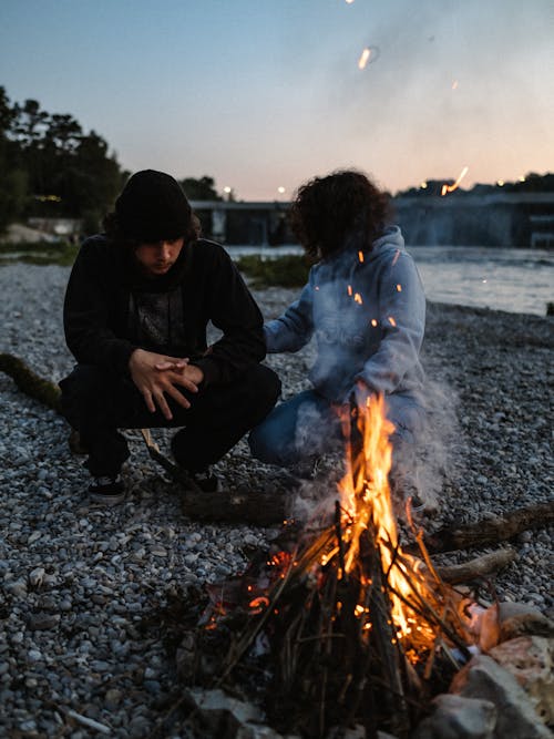 Couple on the Riverbank Having a Fire 