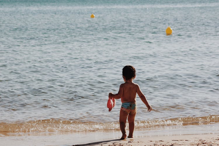 Toddler Walking On Sea Beach