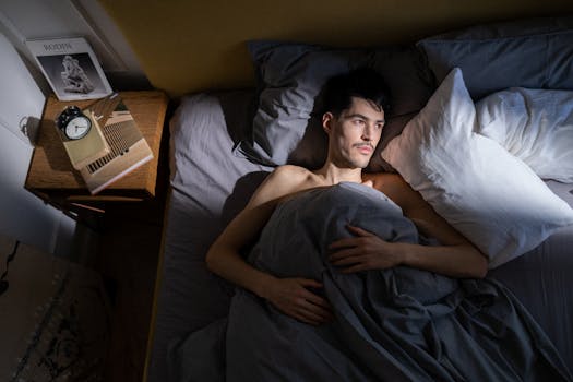 A man in bed enjoying morning sunlight streaming in through the window.