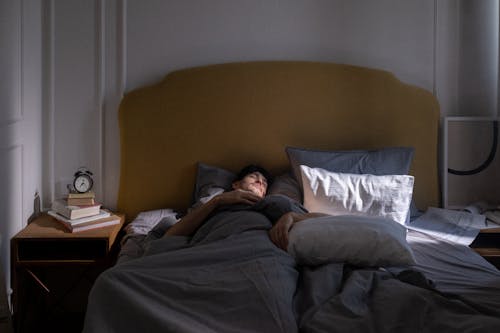 Free Man in Gray T-shirt Lying on Bed Stock Photo
