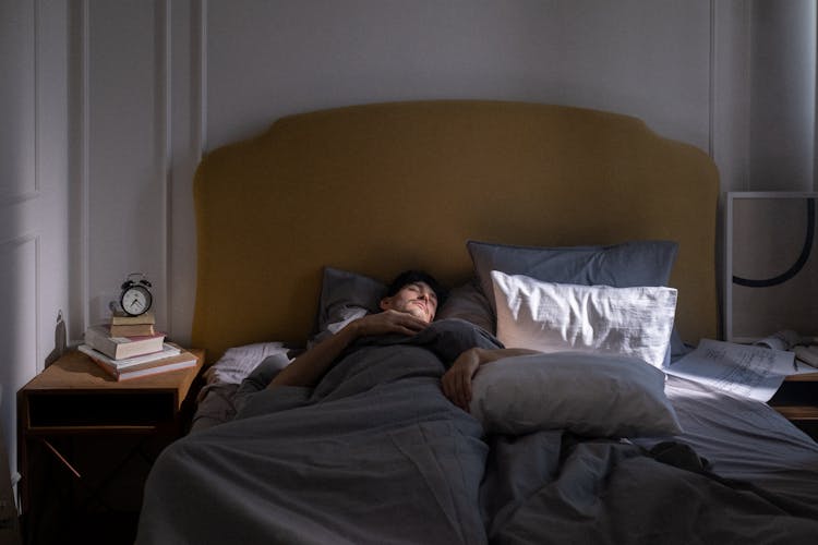 Man In Gray T-shirt Lying On Bed