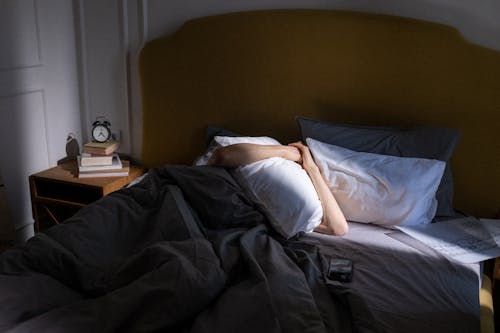 Free Woman Lying on Bed Covered With Black Blanket Stock Photo
