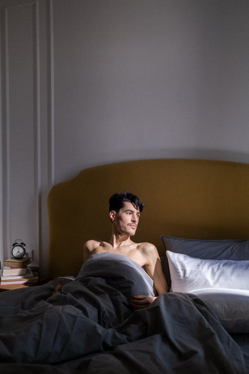 Free Topless Man Lying on Bed Stock Photo
