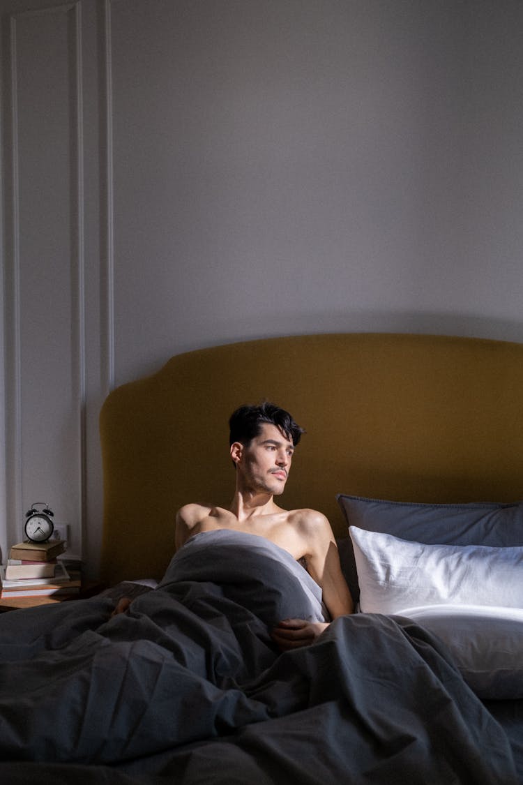 Topless Man Lying On Bed