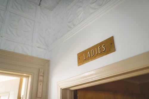 White Concrete Wall with Wooden Signage