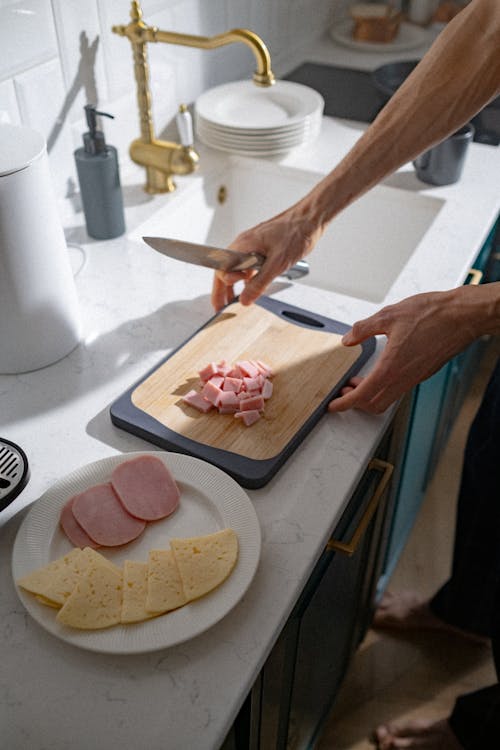 Free Person Slicing Meat on Chopping Board Stock Photo