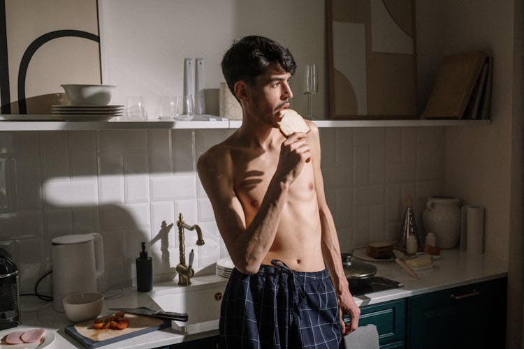 Man In Blue And White Plaid Shorts Standing Near Kitchen Sink