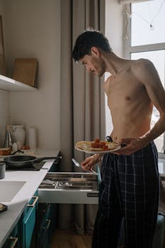 Casual morning in the kitchen with a young man preparing breakfast. Natural light sets a cozy mood.