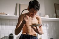 Topless Man in Blue Denim Shorts Holding White Ceramic Plate