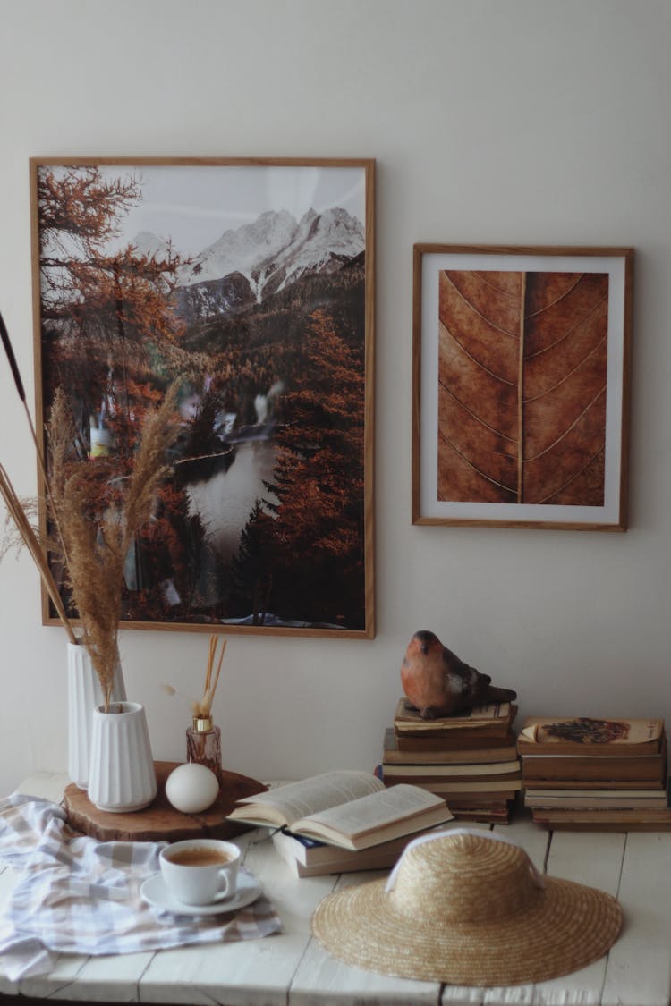 Brown Still Life With Summer Hat, Books And Pictures On Wall