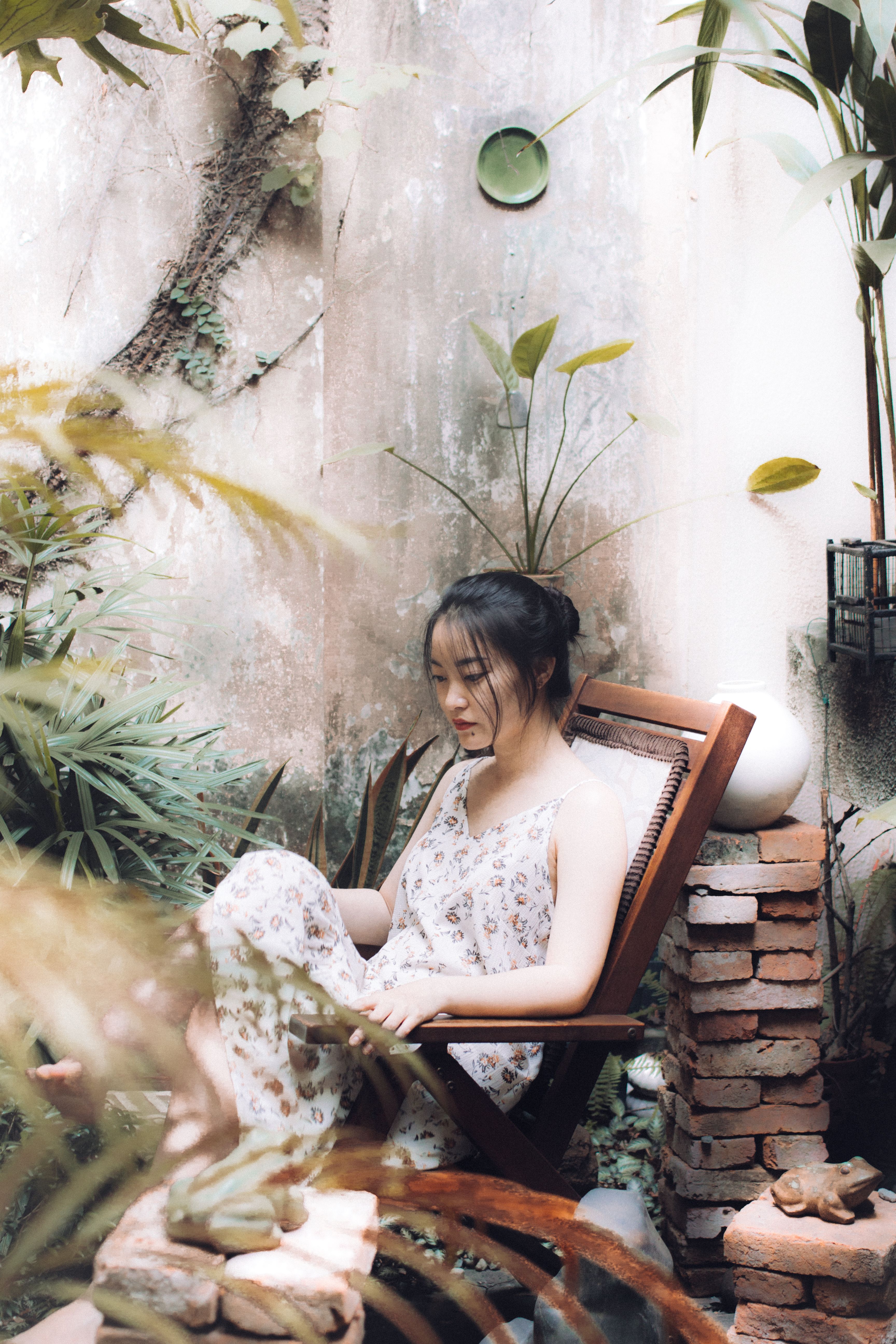 A Woman in Floral Dress Sitting on the Wooden Chair · Free Stock Photo