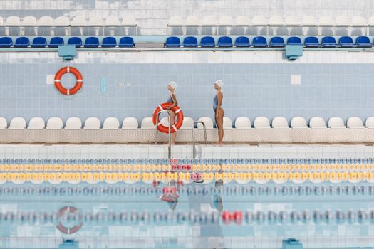 Women Standing by the Poolside Holding a Lifesaver