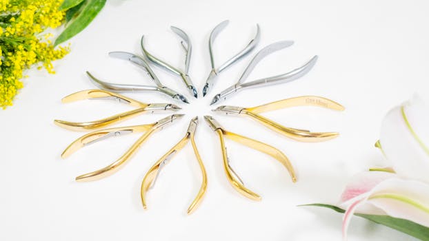 Stylish studio photo of cuticle nippers arranged in a circle with floral accents.