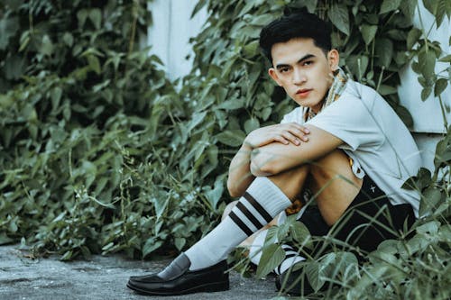 A Man Sitting Beside the Green Plants